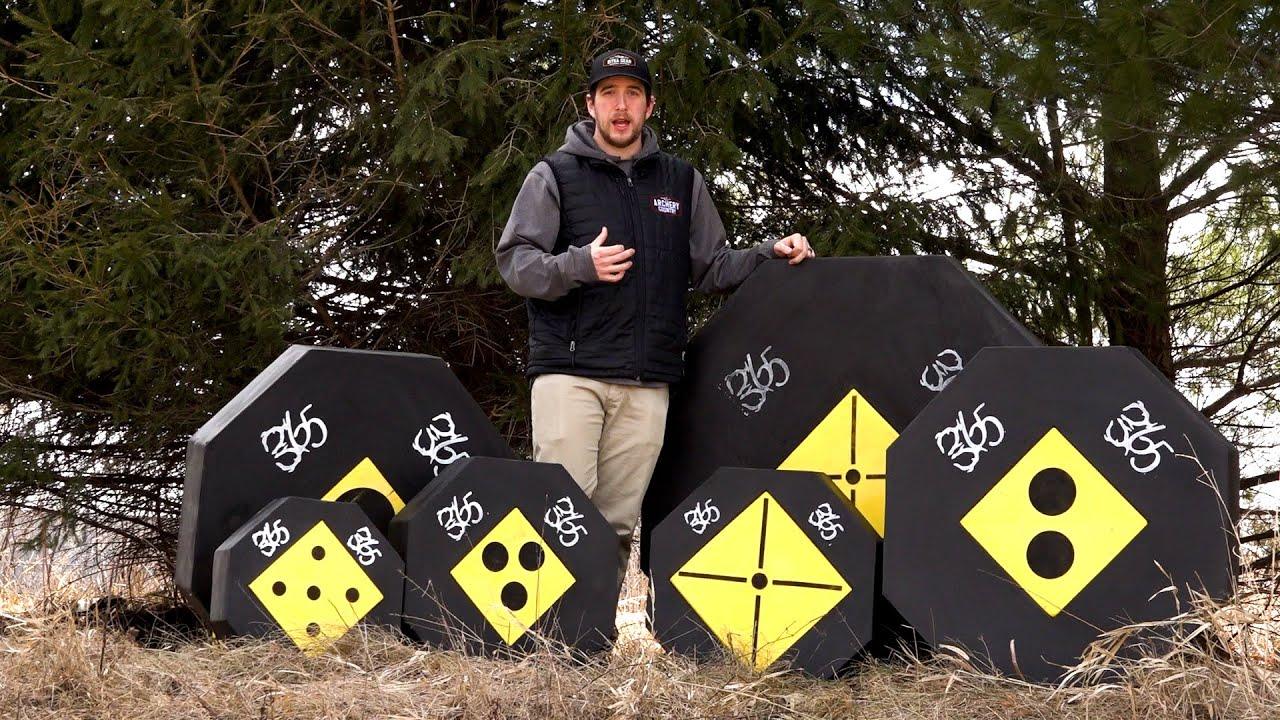 Man posing outdoors with 365 Archery black and yellow targets in grassy area