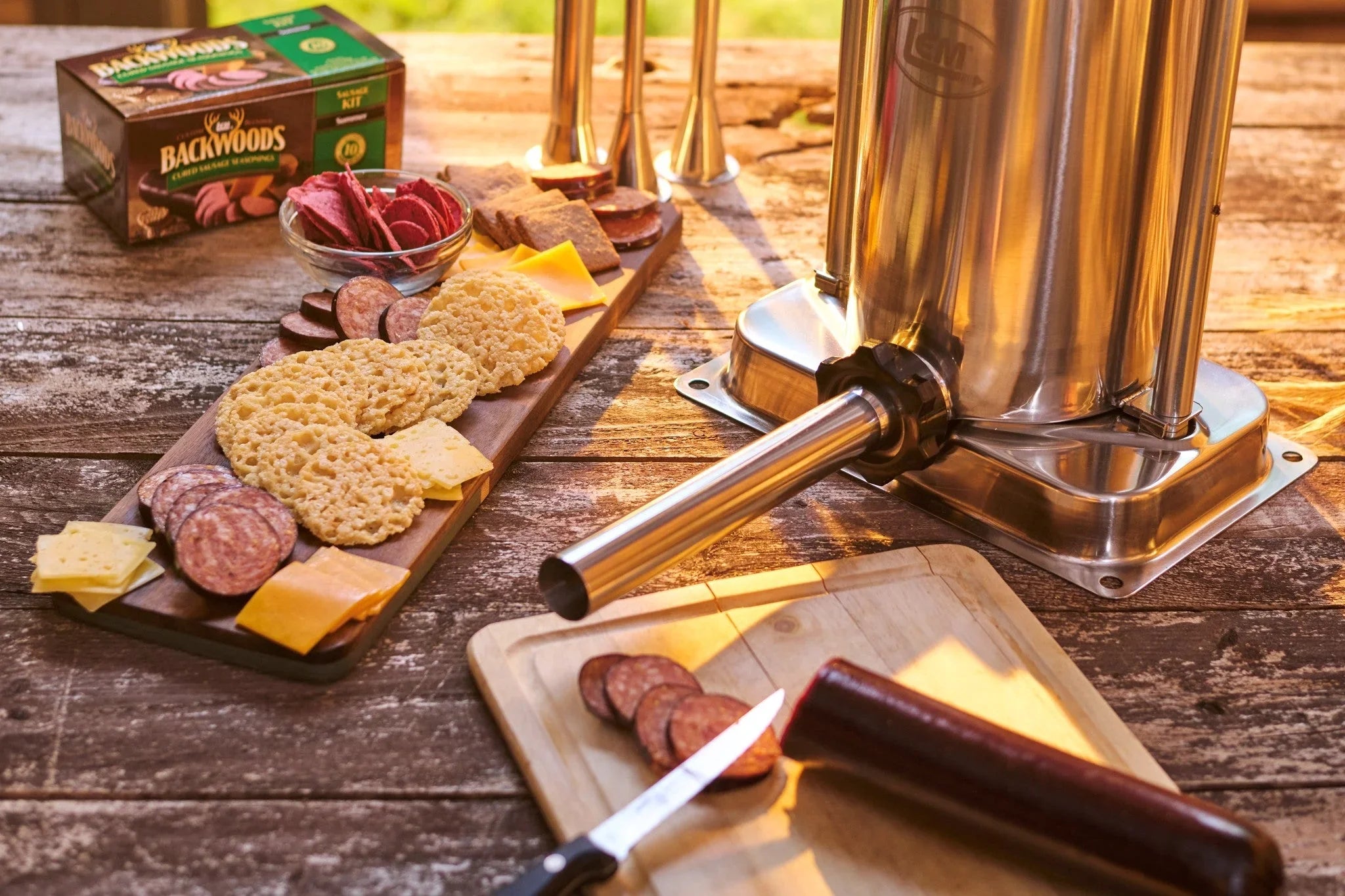 Charcuterie board with sausage, cheese, crackers, sausage stuffer, Backwoods seasoning kit