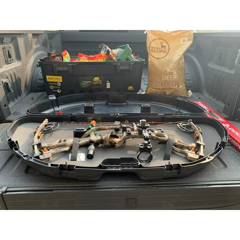 Compound bow in camo case in truck bed with archery gear, deer corn, heavy-duty storage box.