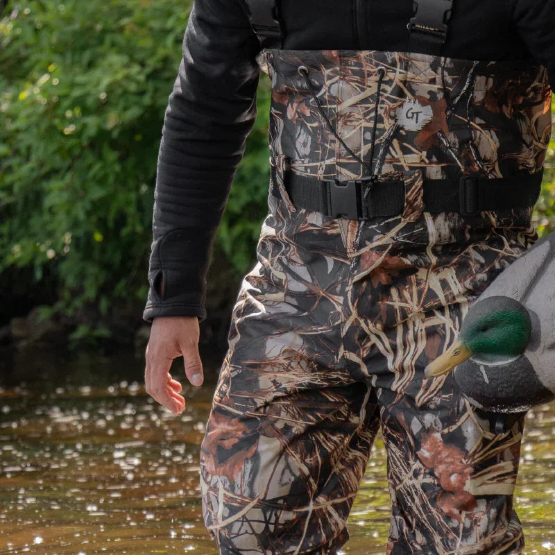 Close-up camo wader pants, water, and duck decoy outdoors