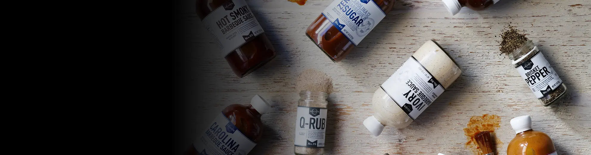 Lillie's Q BBQ sauces and seasonings beside smoked barbecue meats and grilled wild game
