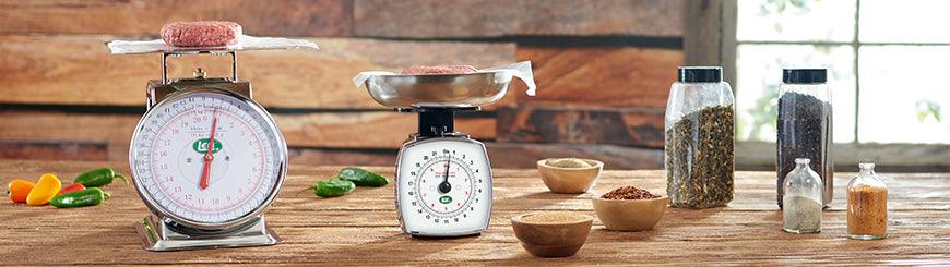 Burger patties on analog scales with spices and seasonings on rustic kitchen counter