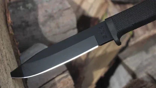 Cold Steel SRK fixed blade survival knife with black handle on chopped wood
