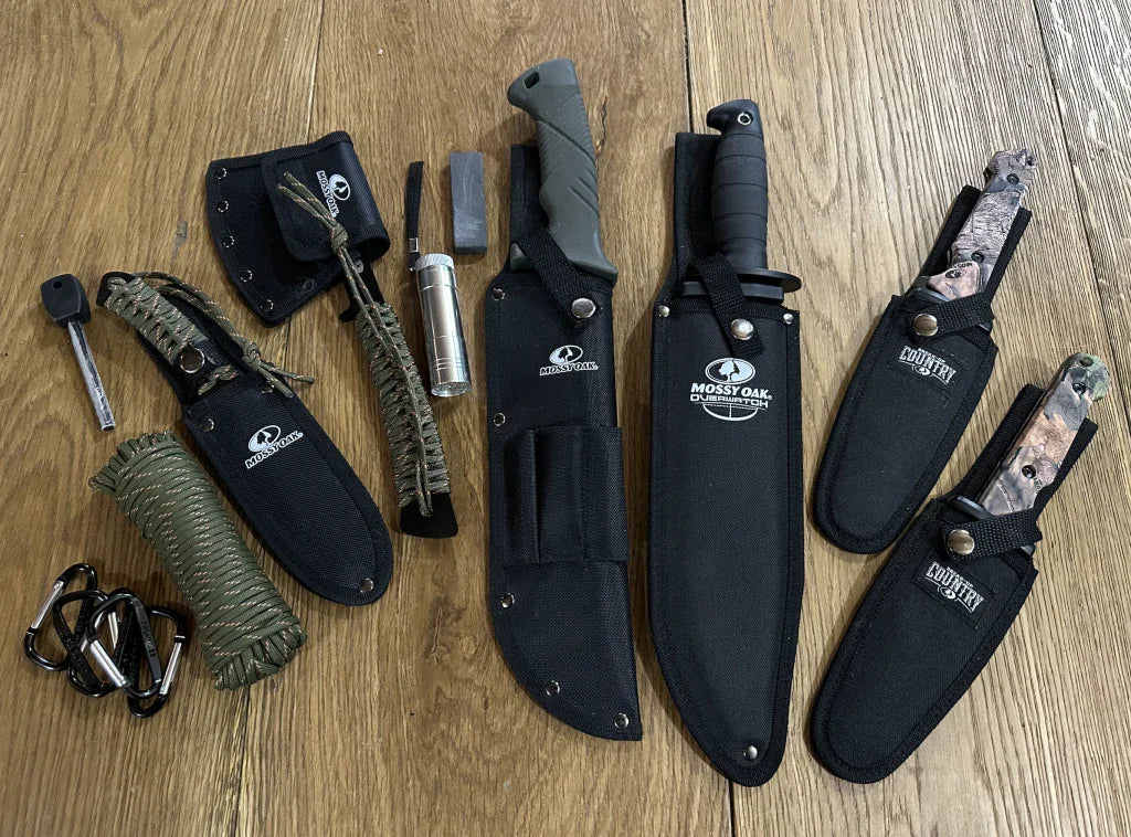 Mossy Oak knife and axe tool set bundle with sheaths, paracord, fire starter and carabiners on wood floor