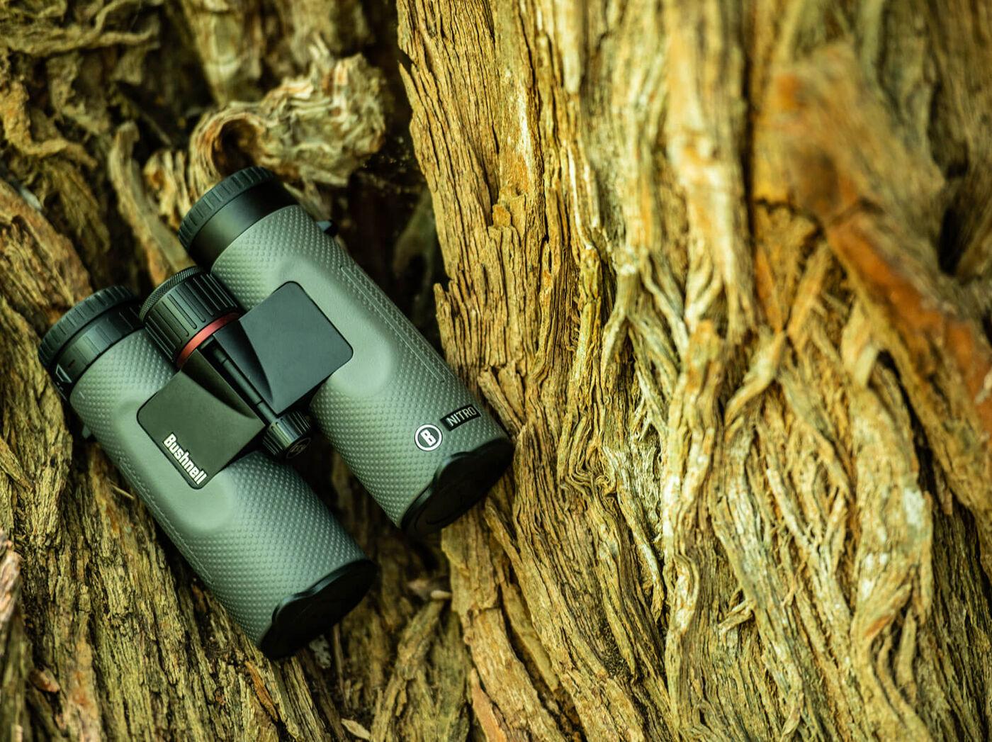 Bushnell Nitro binoculars resting on textured tree bark outdoors