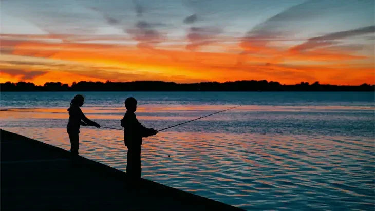 People fishing on a dock at sunset over Lake Erie in Leamington