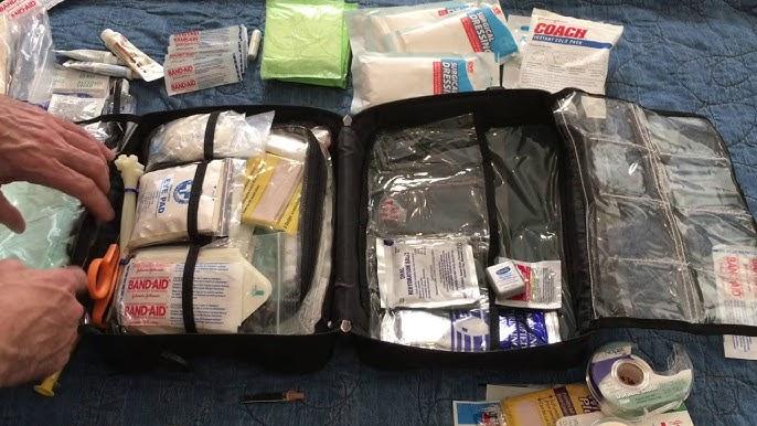 Open first aid kit with bandages, gauze, scissors, and medical supplies on a blue surface