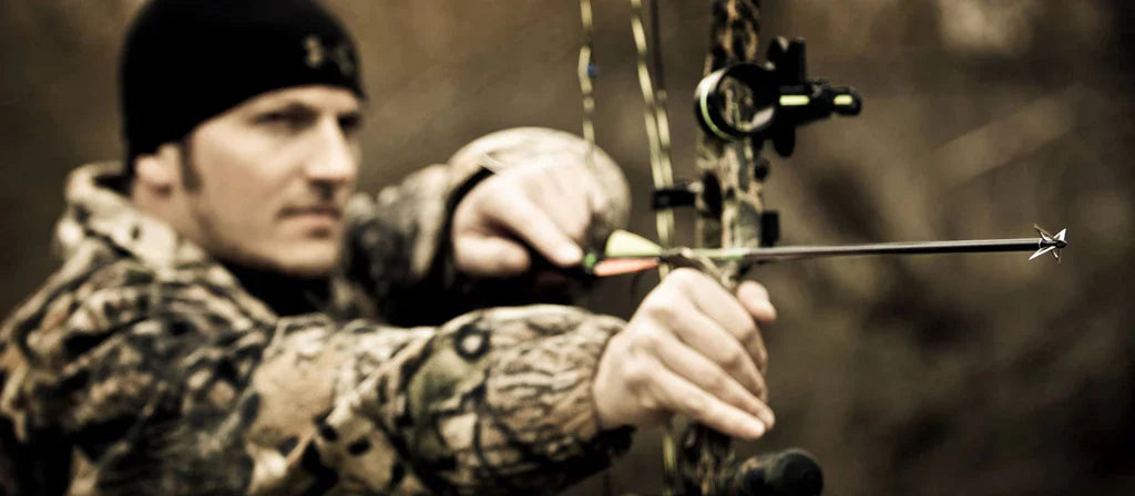 Slick Trick archery broadhead on black and yellow banner with 'No Excuses Broadheads' text