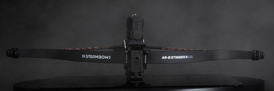 Steambow AR-6 Stinger II crossbow on black surface with smoky dark background