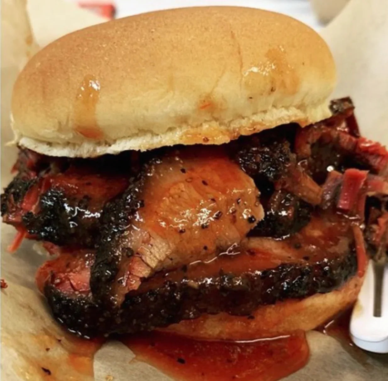 Barbecue brisket sandwich with smoky sliced meat and barbecue sauce on a soft bun
