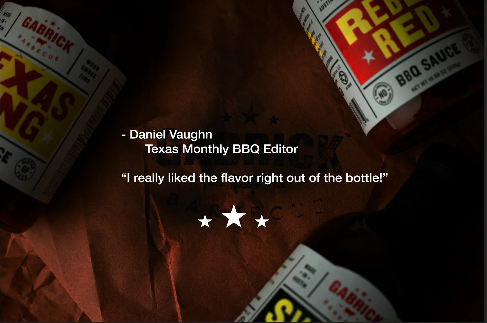 BBQ sauce bottles on brown paper with a customer testimonial about flavor, featuring Gabrick Barbecue Texas Tang and Rebel Red labels.