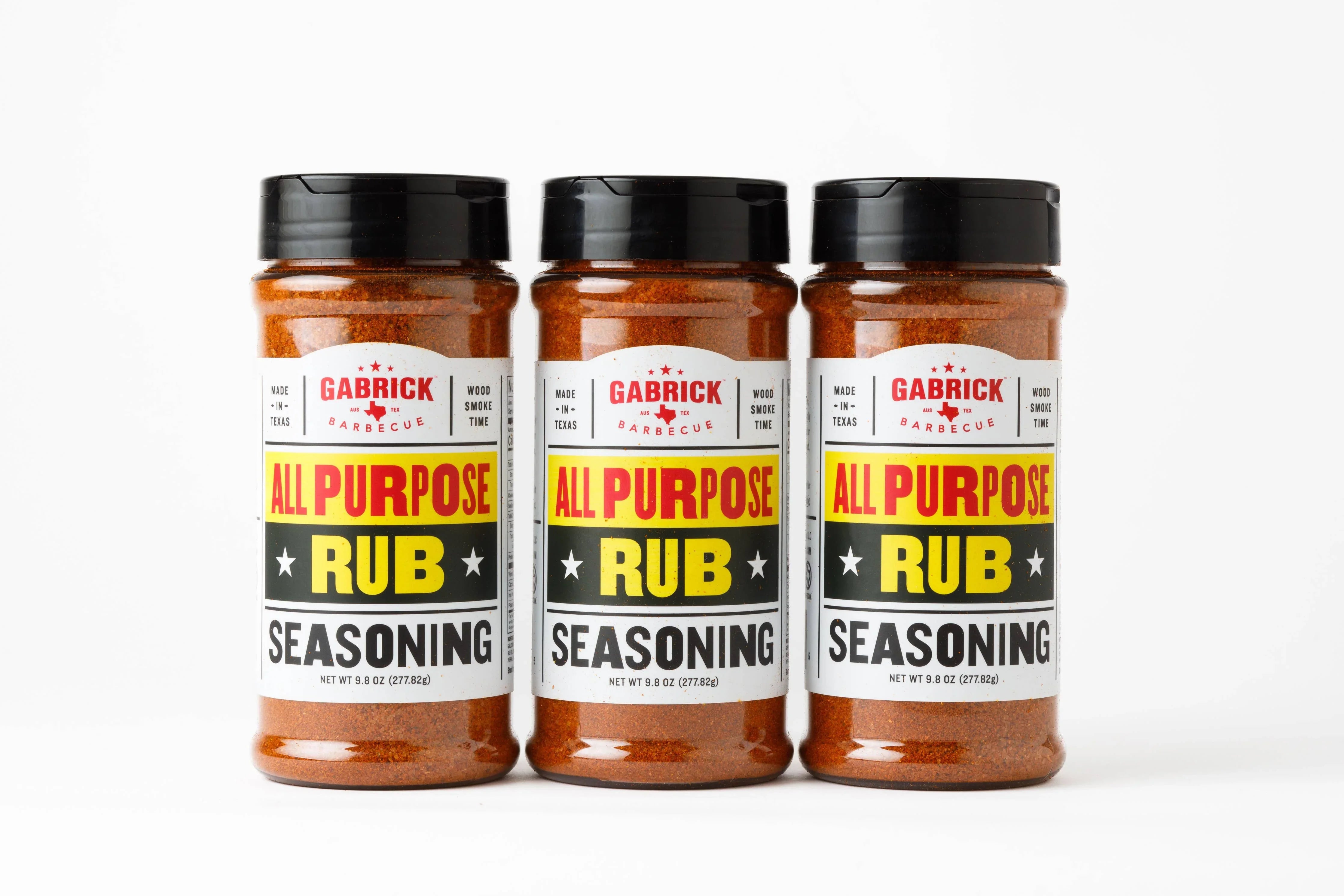 Three bottles of all purpose barbecue rub seasoning with black lids on white background