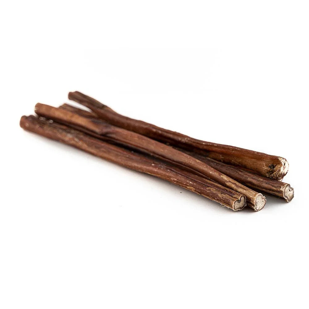 Pile of natural 12 inch bully sticks dog chews on white background