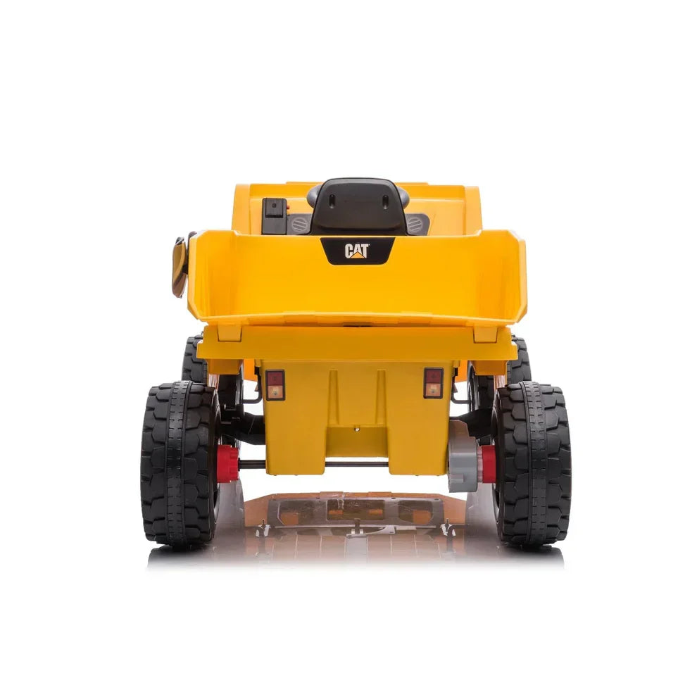 Rear view of yellow CAT 12V electric ride-on dump truck for kids with large black wheels on white background