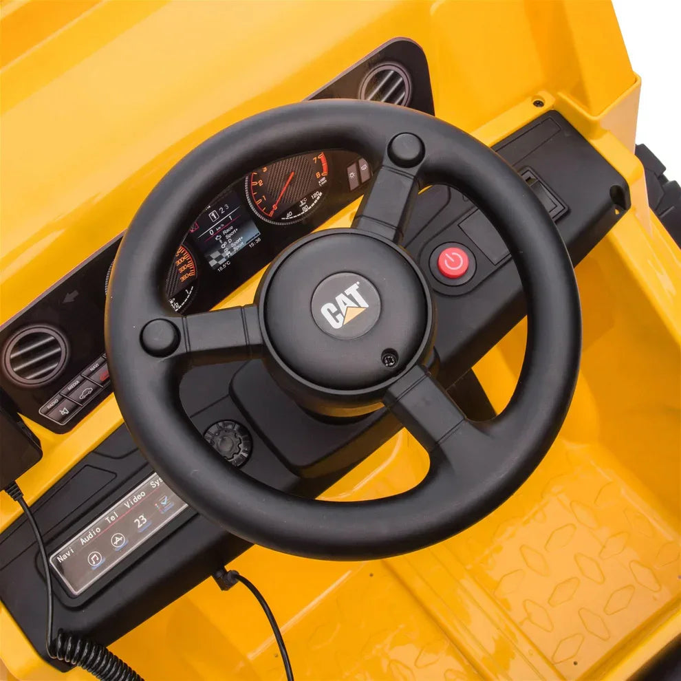 Close-up of CAT-branded black steering wheel and dashboard on yellow 12V electric kids ride-on dump truck