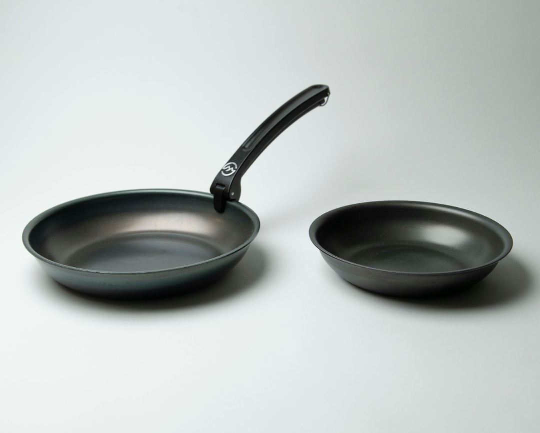 Two nonstick camping frying pans, one with a handle, on a white background