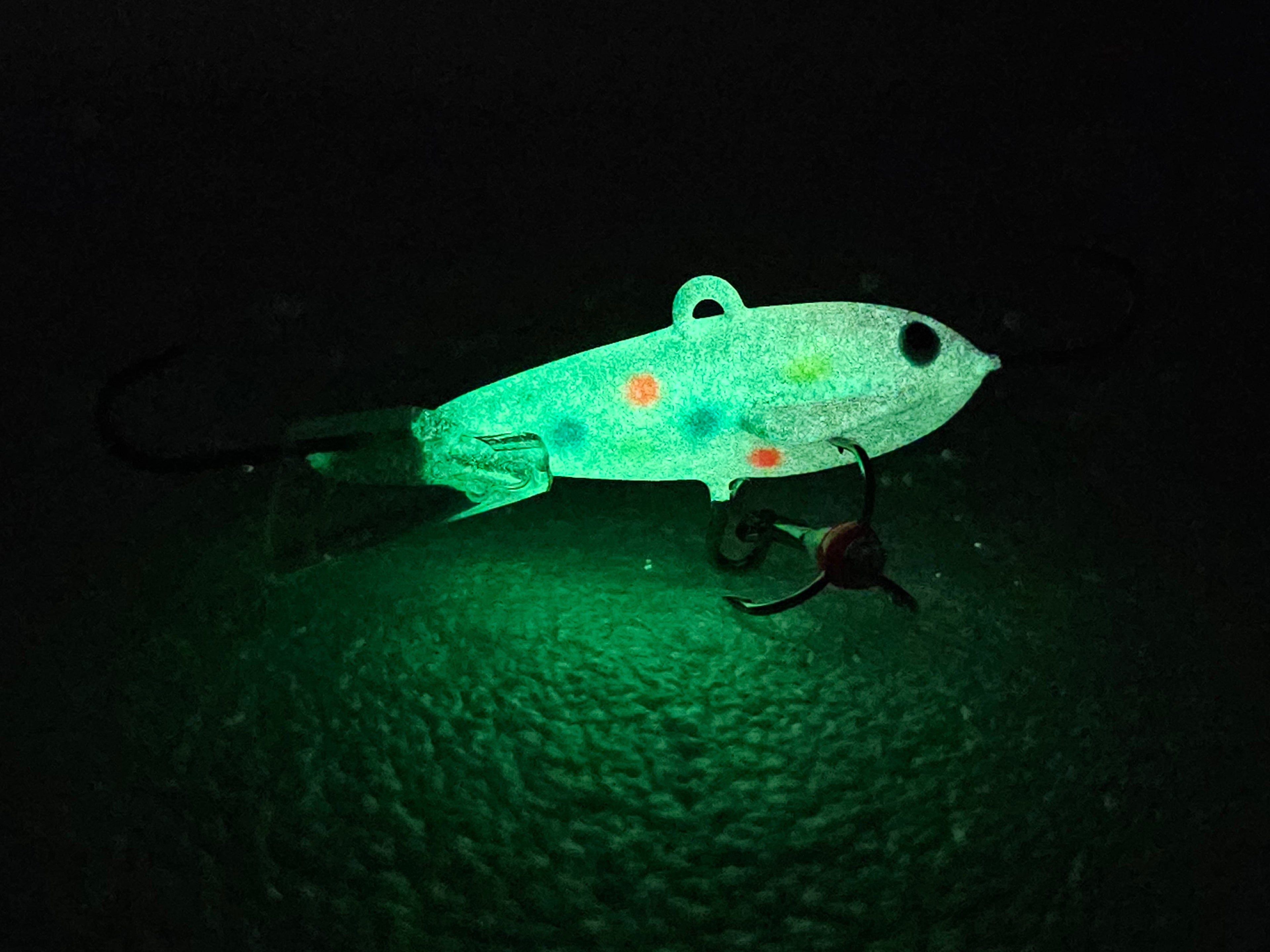 Glow in the dark ice fishing jig with hooks, ideal for night fishing lures.