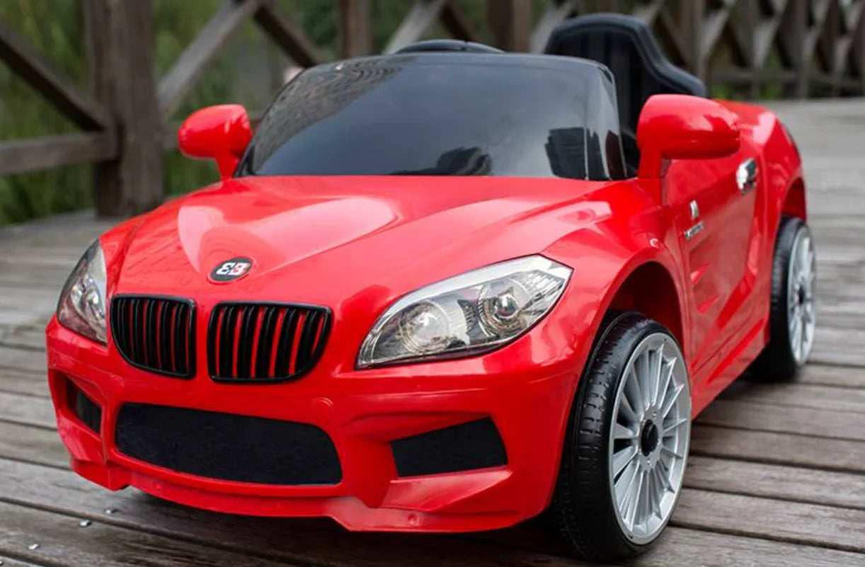 Red toy car for kids with black windshield and silver wheels on wooden deck