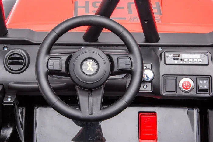 Toy car dashboard with black steering wheel, red controls, and electronic display panel.