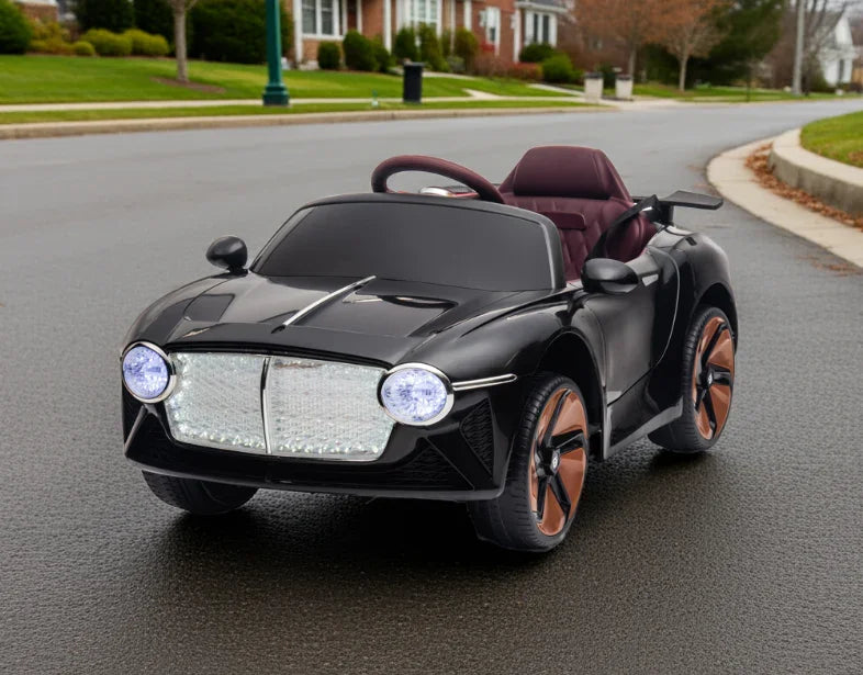 Black kids' electric ride-on car with headlights on, parked on residential street