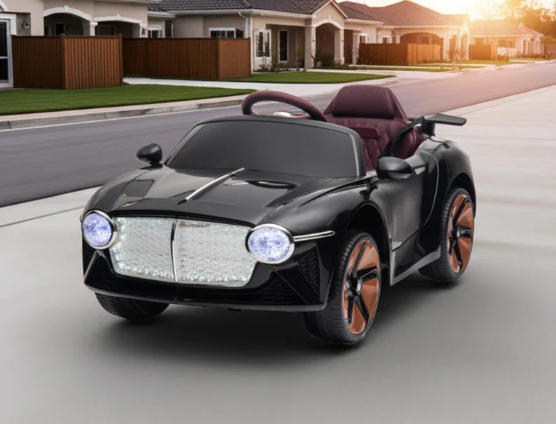 Black kids electric ride-on toy car with LED headlights on suburban driveway