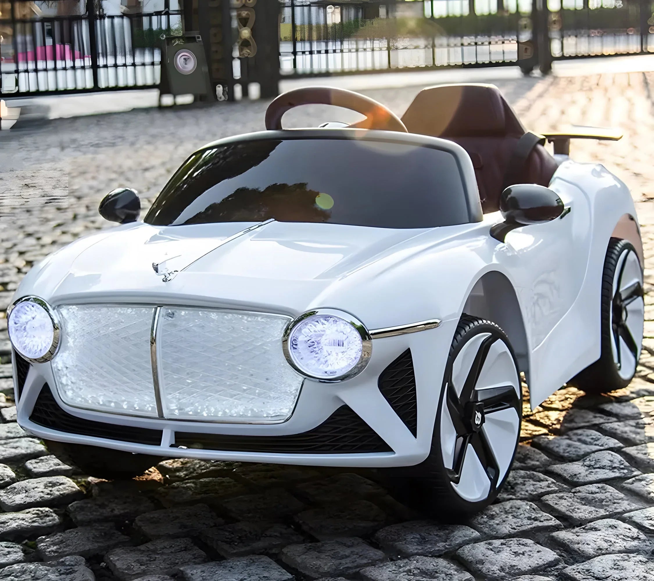 White kids electric ride-on car with LED headlights on cobblestone street