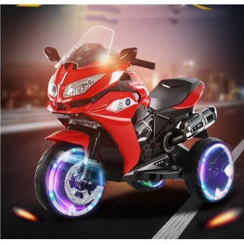 Red kids electric ride-on motorcycle with LED wheels on a city street at night