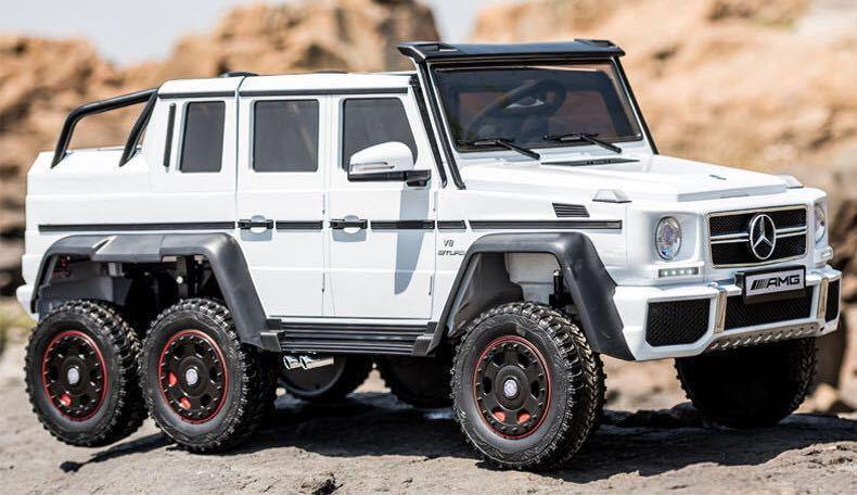 White Mercedes-Benz G63 AMG 6x6 off-road SUV toy model on rocky outdoor terrain