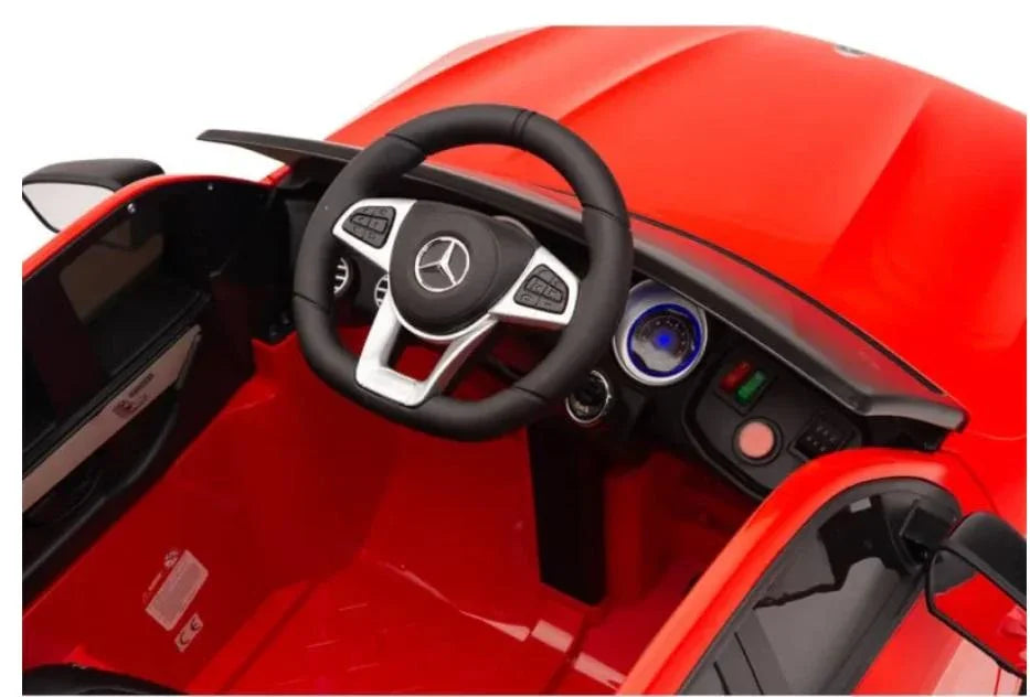 Red Mercedes kids ride on car interior with steering wheel and dashboard