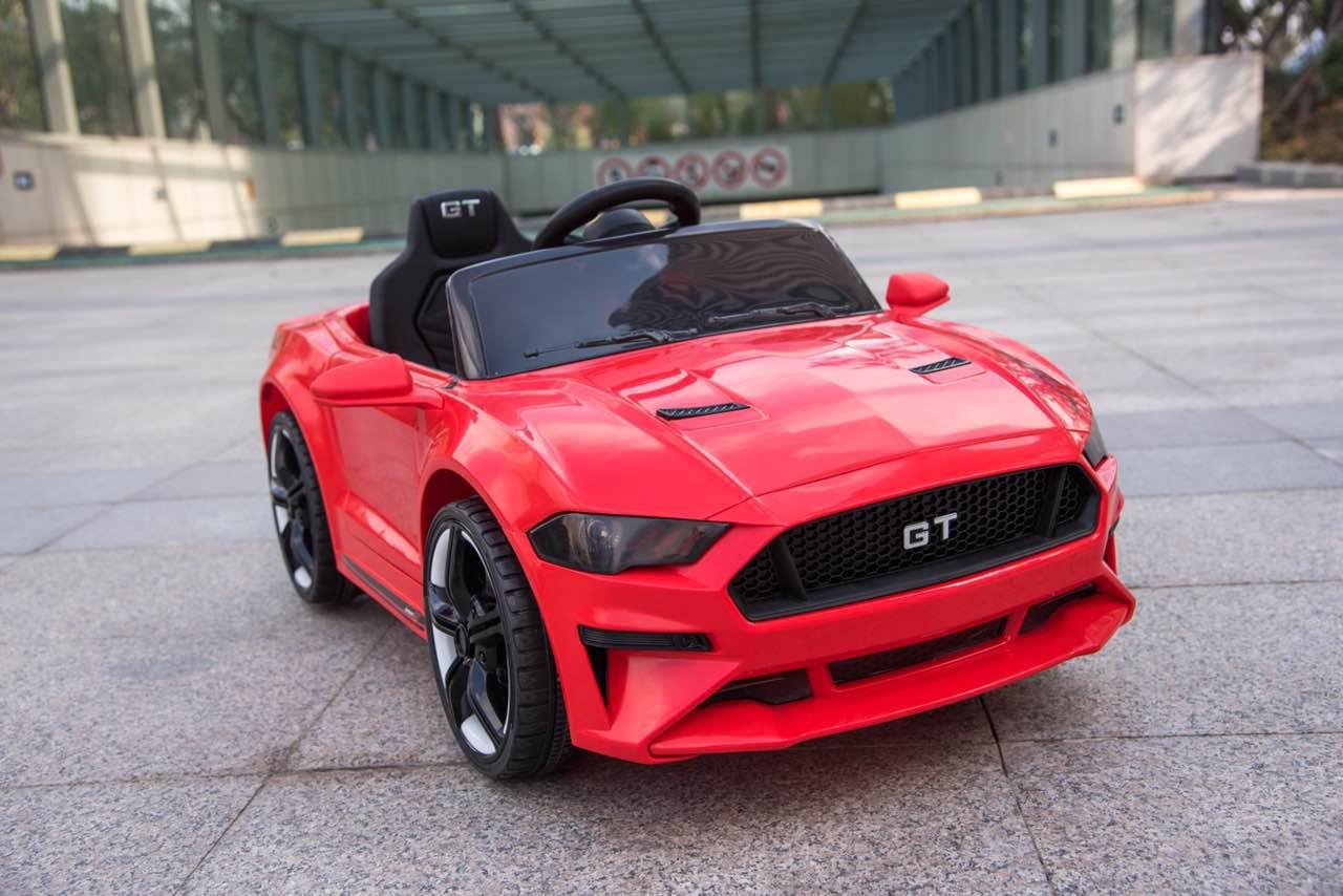 Red GT ride-on toy car for kids parked outdoors on pavement