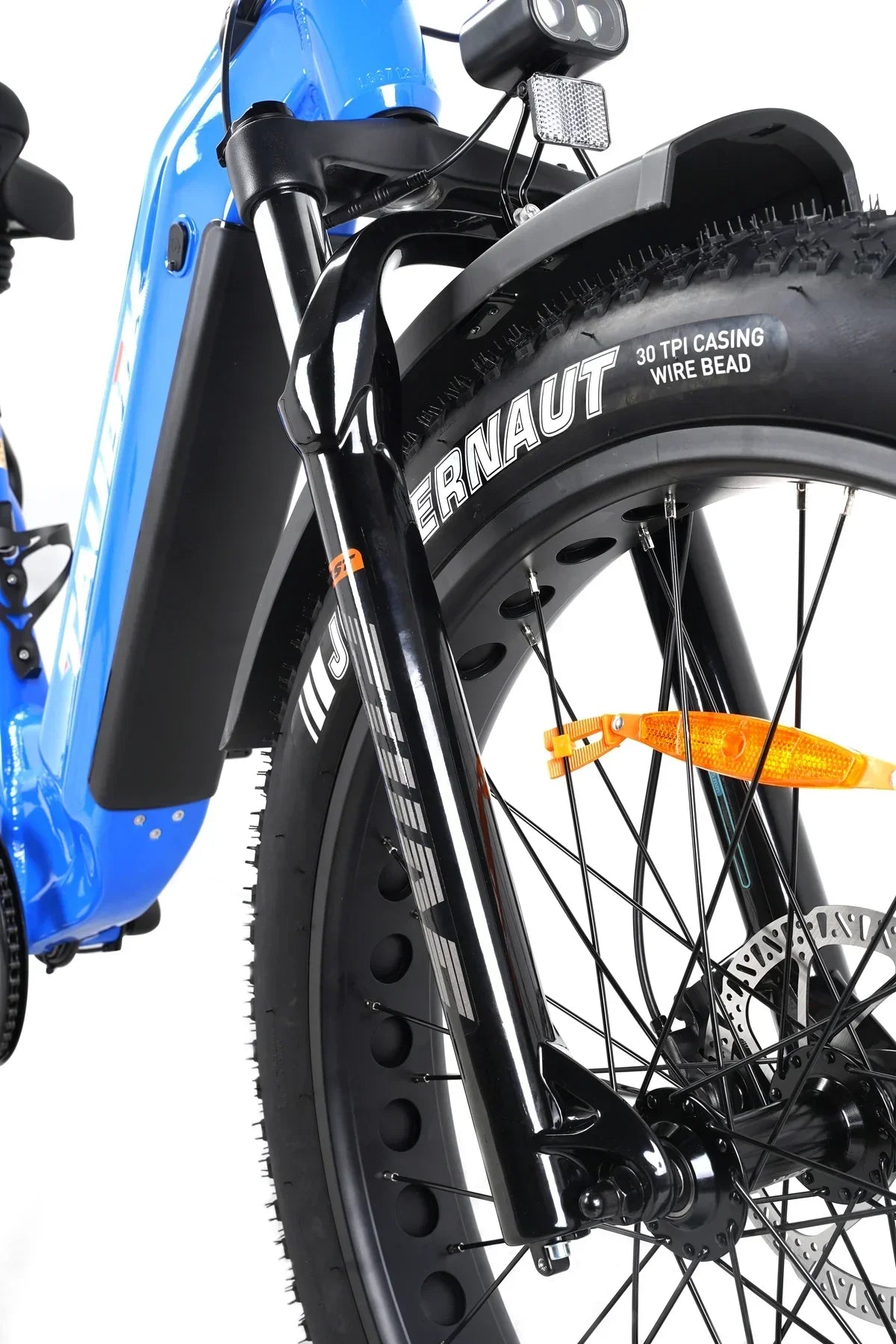 Close-up of Taubik Tour blue electric bike front tire, suspension fork, and wide tread