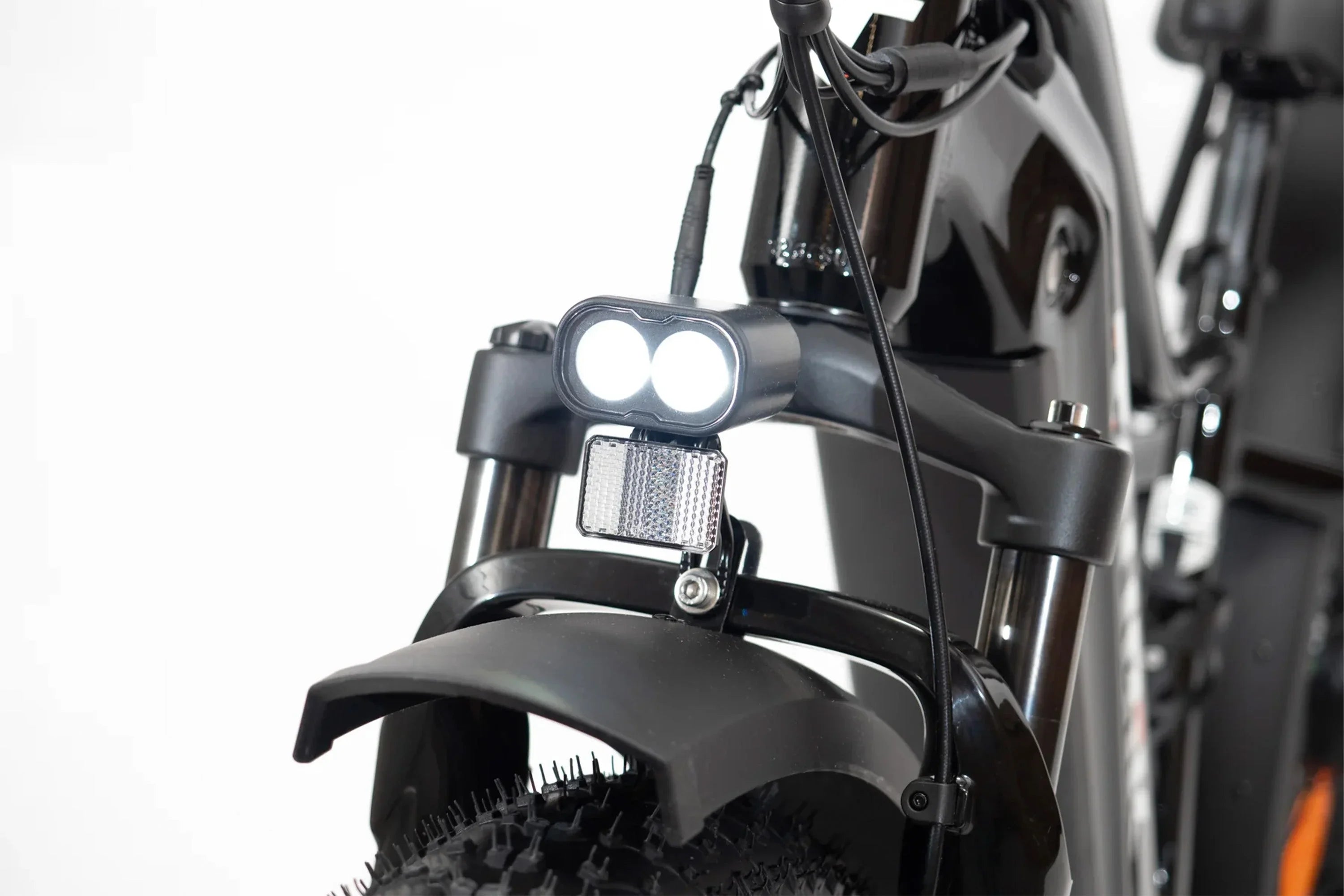Front LED headlight and reflector on black Taubik Westridge 4T off-road eBike tire
