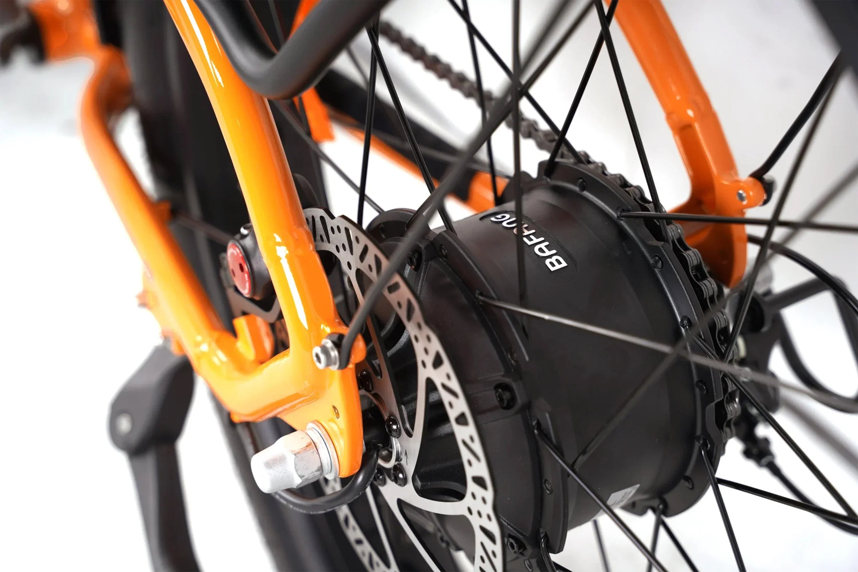 Close-up of orange Taubik Westridge 4T e-bike rear wheel with Bafang motor and disc brake