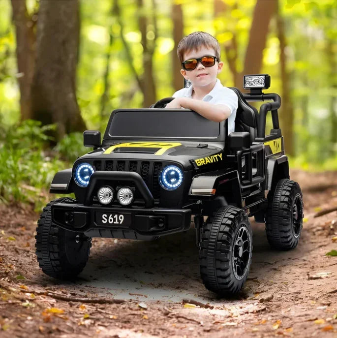 Boy driving black electric toy jeep with headlights in forest path, kids ride-on car