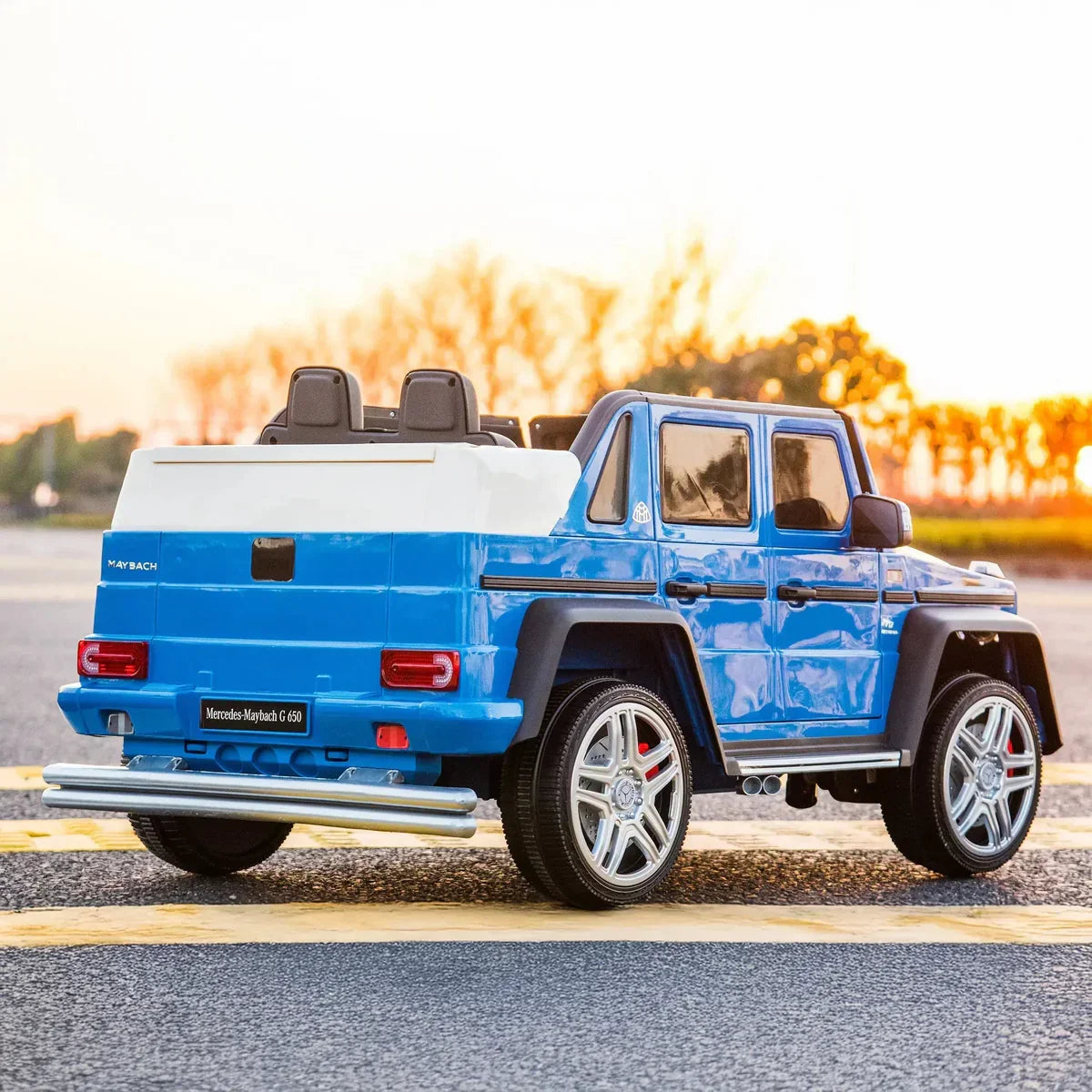 Blue Mercedes-Maybach G 650 kids ride-on car outdoors at sunset