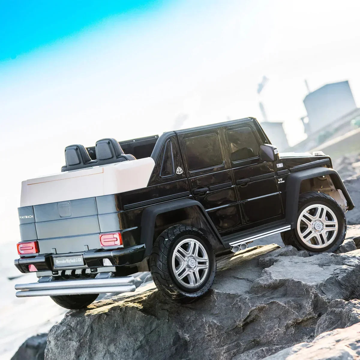 Black Mercedes Maybach G650 ride-on toy SUV on rocky terrain outdoors