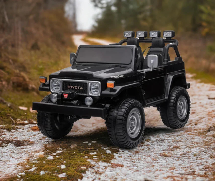 Black Toyota Land Cruiser toy car on gravel path in outdoor forest setting