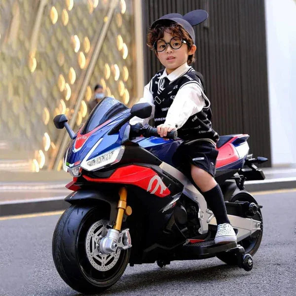 Young boy riding a blue and red kids electric motorcycle bike on a city street