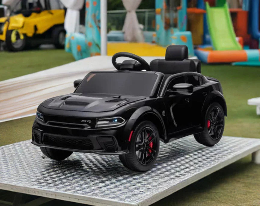 Black kids ride-on toy car outdoors on metal ramp with playground in background