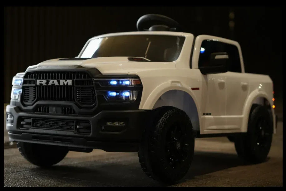 White RAM toy truck ride-on car with realistic headlights, parked indoors at night