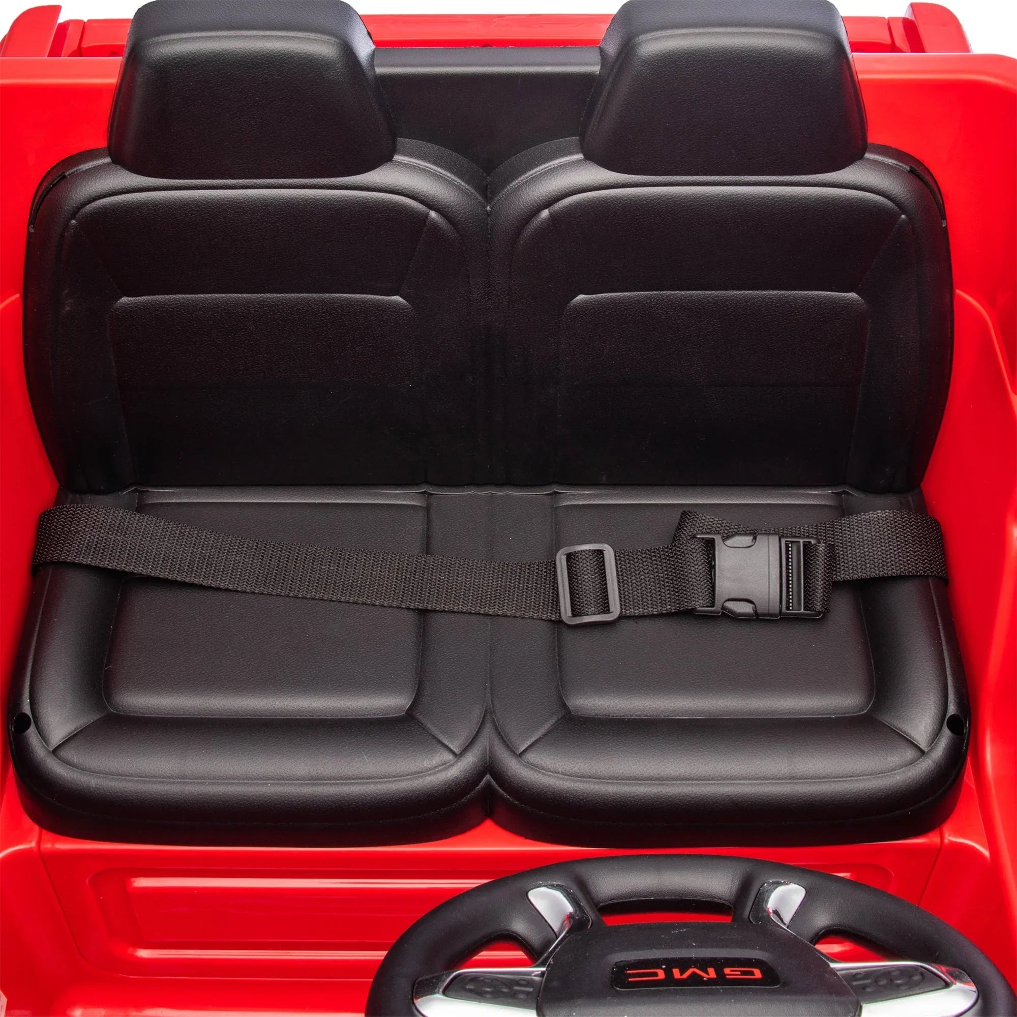 Black leather two-seat interior with seatbelt in a red GMC toy car