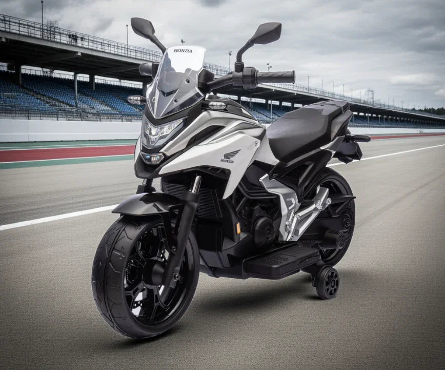 White Honda motorcycle with training wheels on a race track under cloudy sky