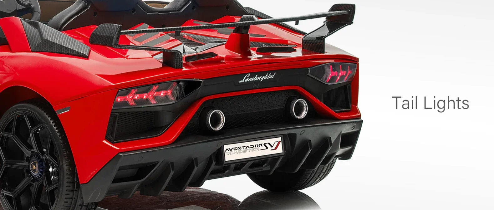 Red Lamborghini Aventador SV roadster rear with illuminated tail lights and spoiler