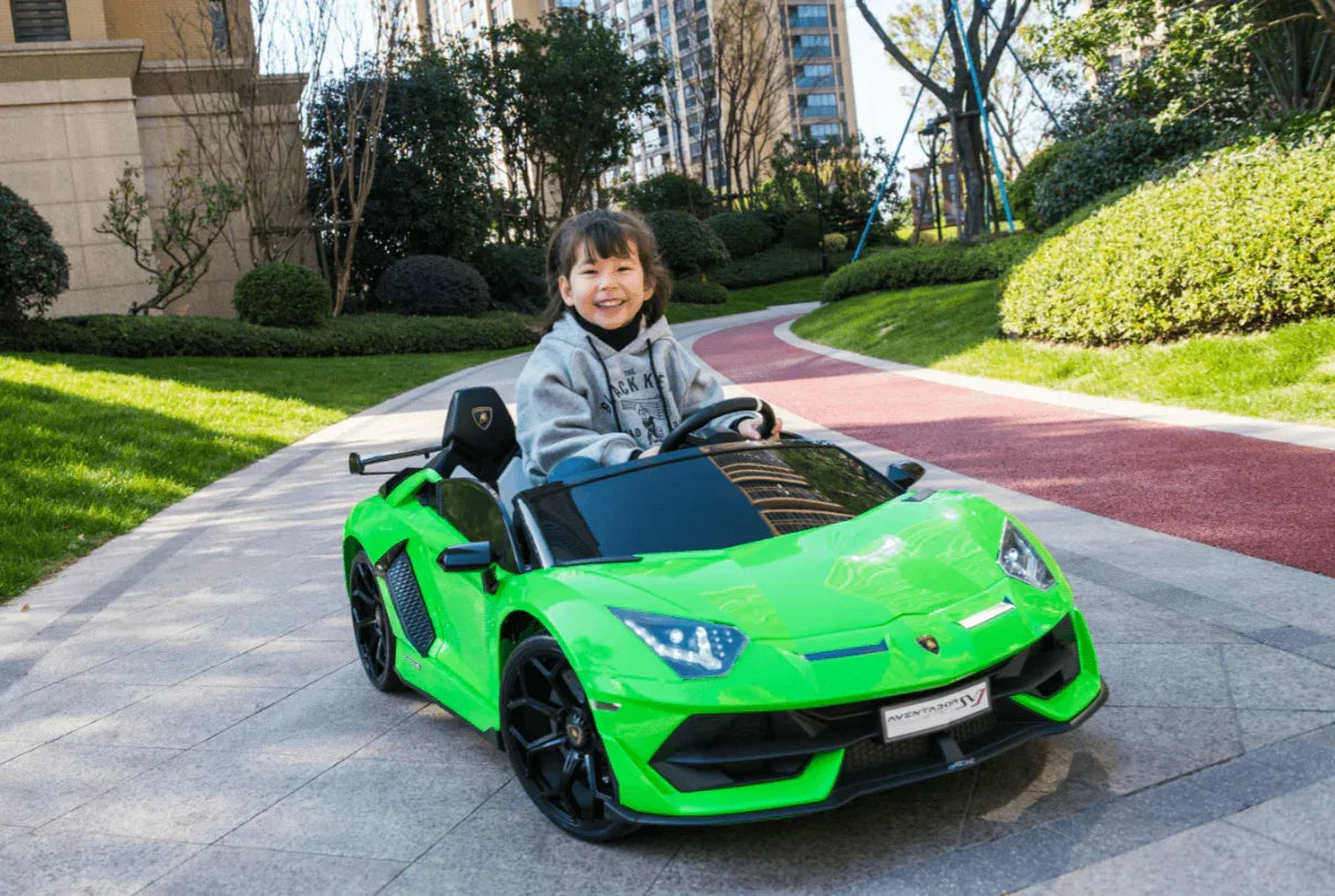 Smiling child driving green Lamborghini toy car outdoors on park path