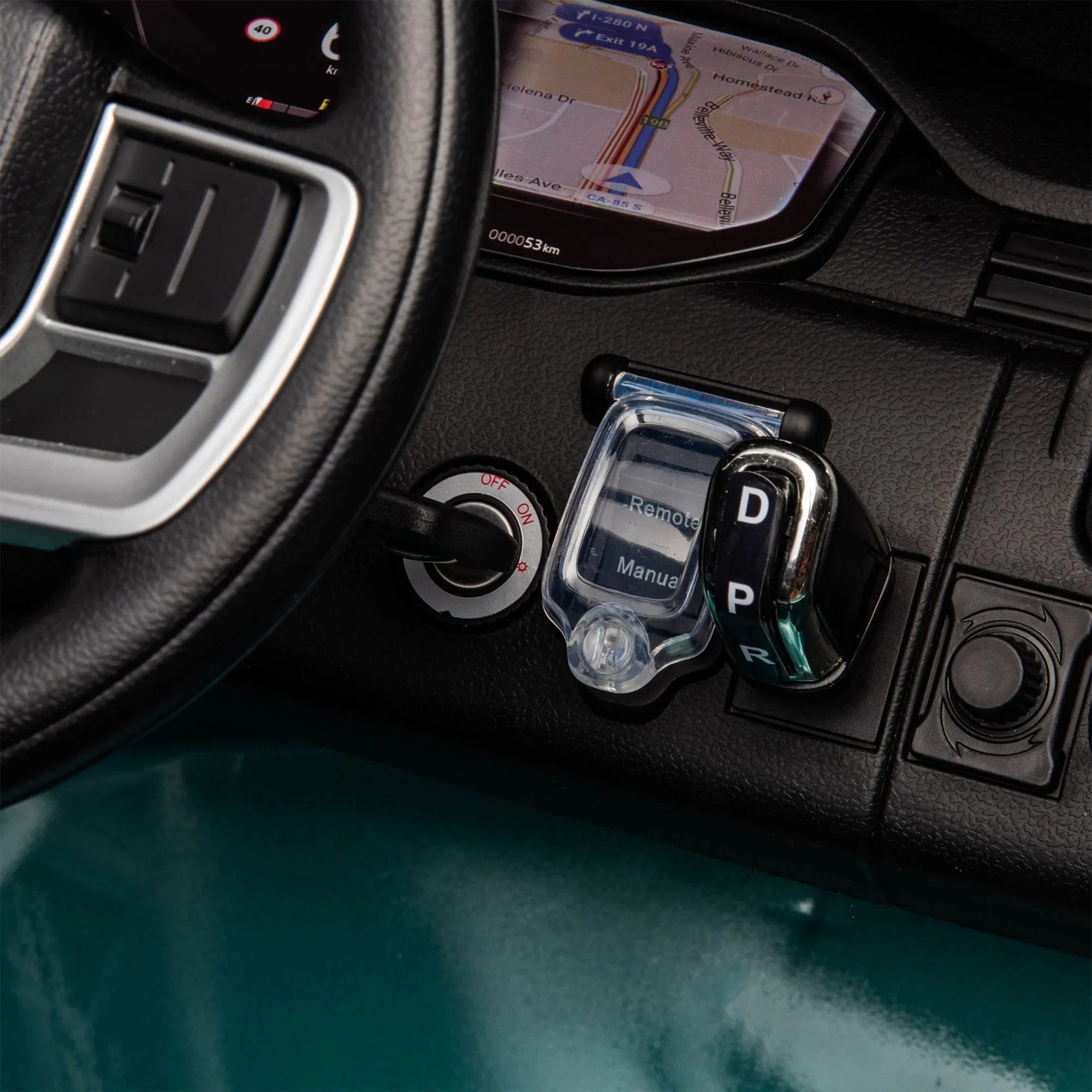 Toy car dashboard with steering wheel, ignition switch, and gear selector D P R