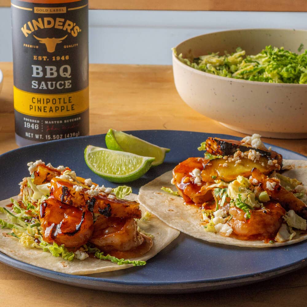 Grilled shrimp tacos with chipotle pineapple BBQ sauce, served with lime wedges and fresh cabbage
