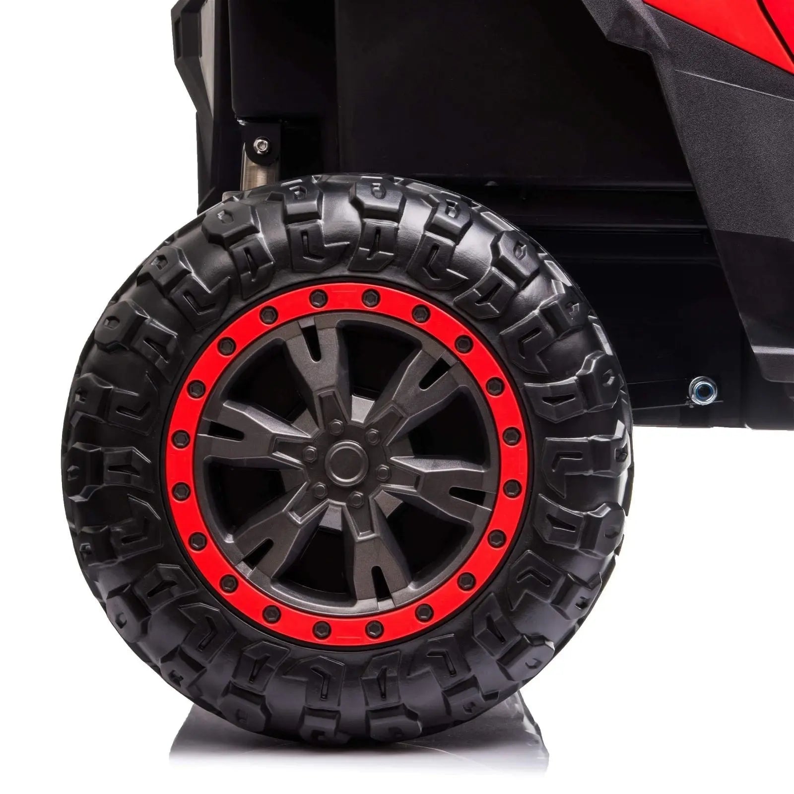 Close-up of rugged black ride-on buggy wheel with red rim on white background