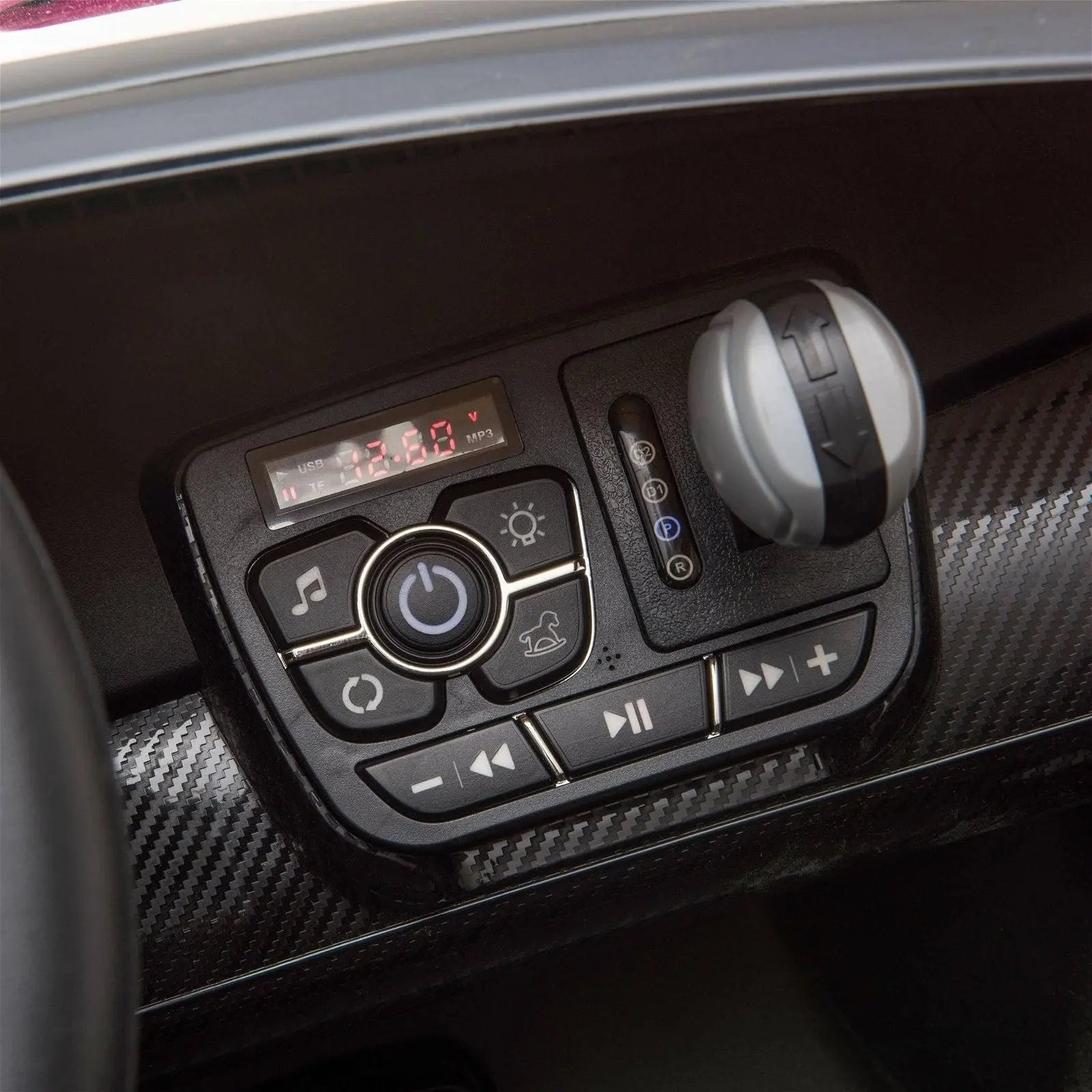 Close-up of ride-on toy car dashboard with control buttons, gear shift, and digital display.