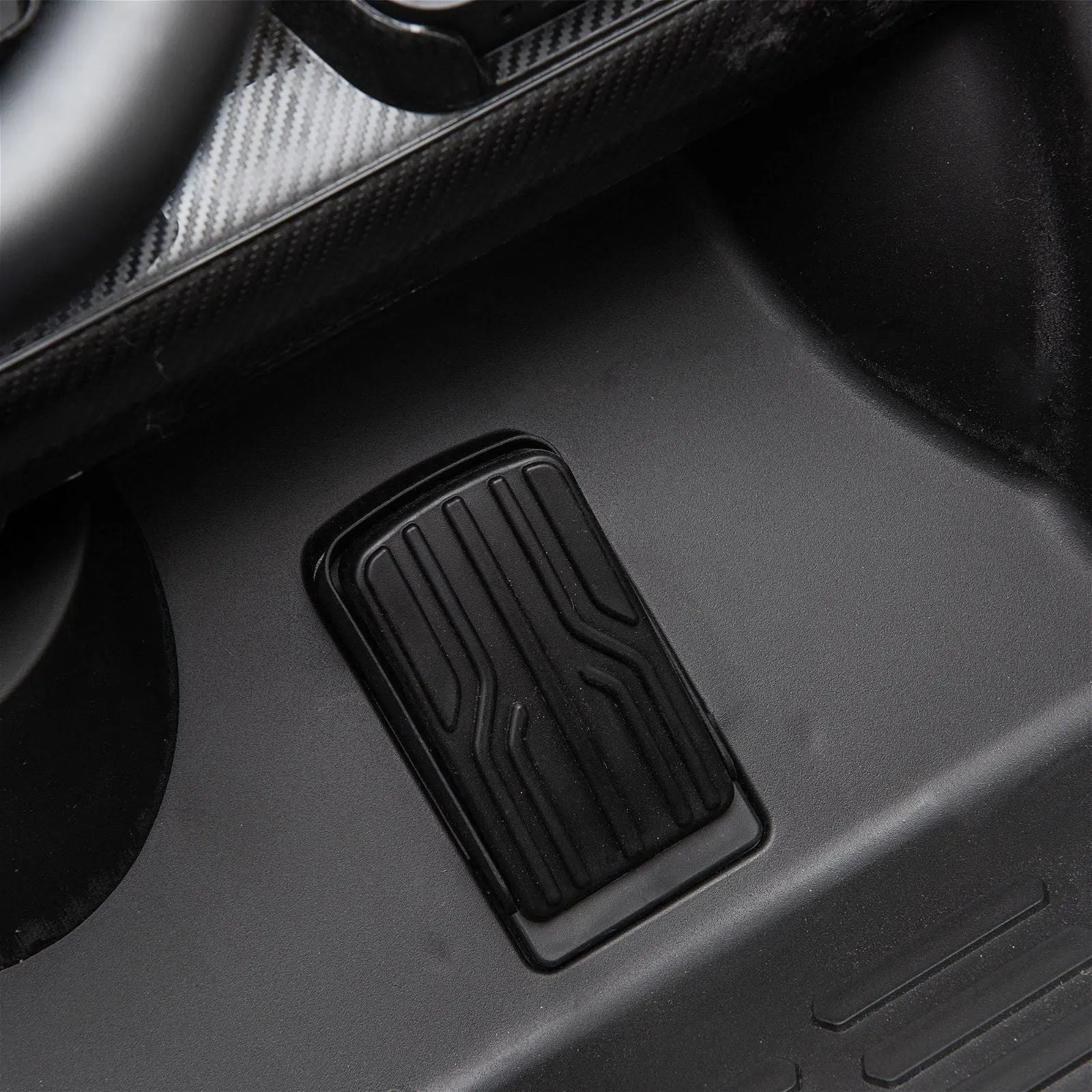 Close-up of ride-on car accelerator pedal on black plastic floor interior