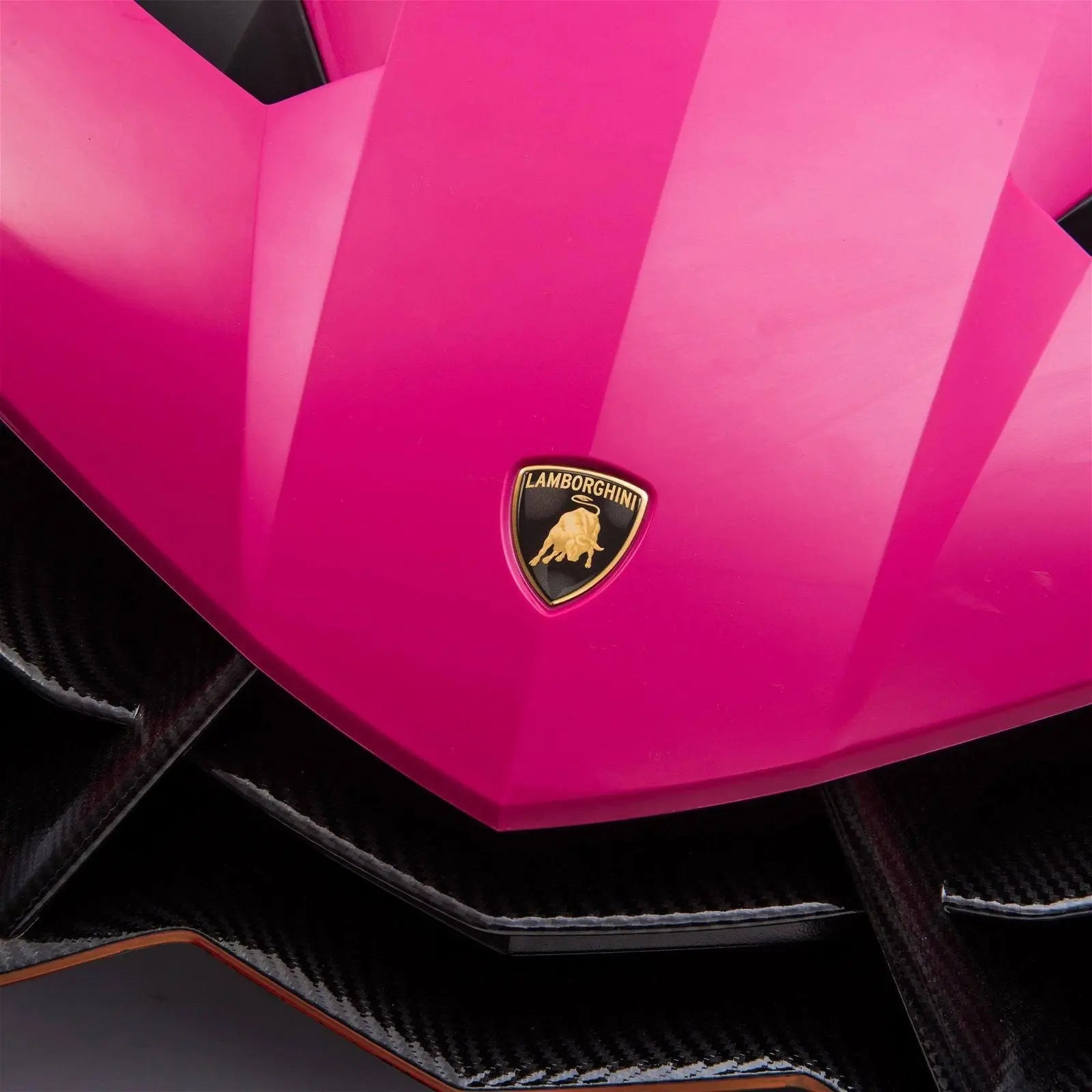 Close-up of a pink Lamborghini Veneno ride-on toy car hood with emblem
